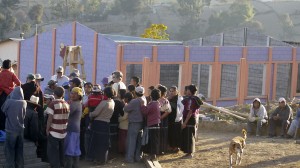 Closing ceremonies with mostly built school in background.